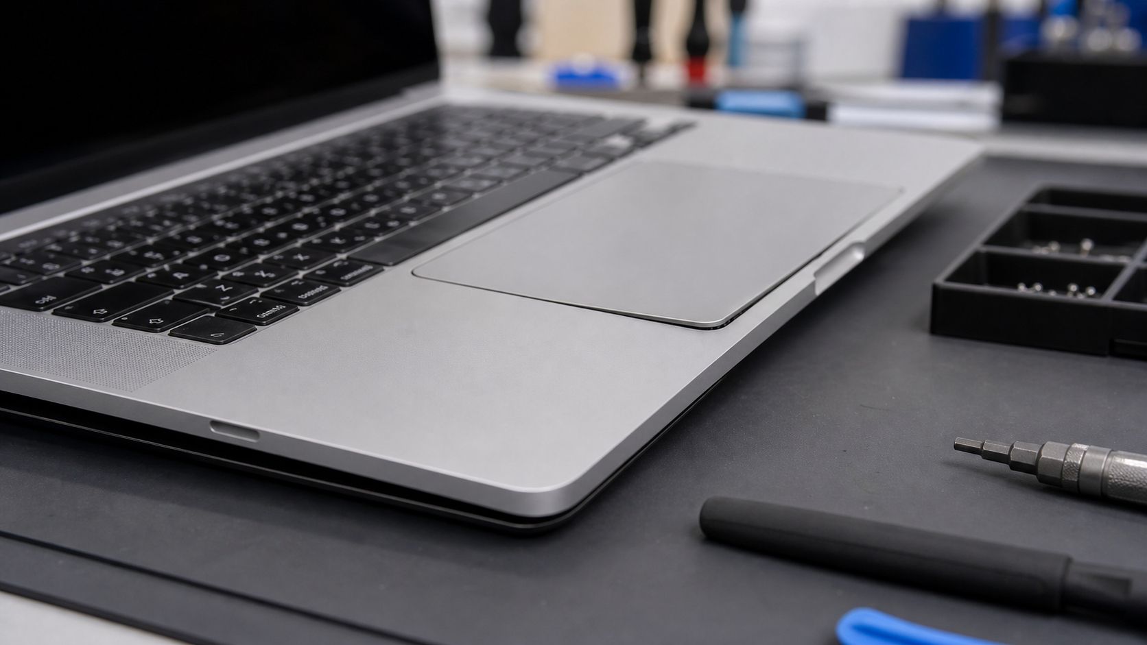 MacBook alt kasasında trackpad çevresindeki hafif baskıyı gösteren yakın plan teknik servis görseli