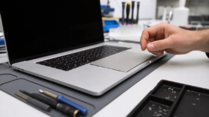 Servis tezgahında trackpad bölgesi odakta olan MacBook Pro için profesyonel arıza kontrolü