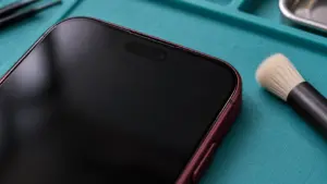 Burgonya iPhone 18 Pro Max tasarımlı telefonun üst ön kenarı ve yanında yumuşak fırça
