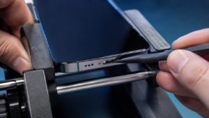 Gevşek USB-C ve Lightning iPhone portunu büyütmeyle inceleyen Fppro teknisyeni