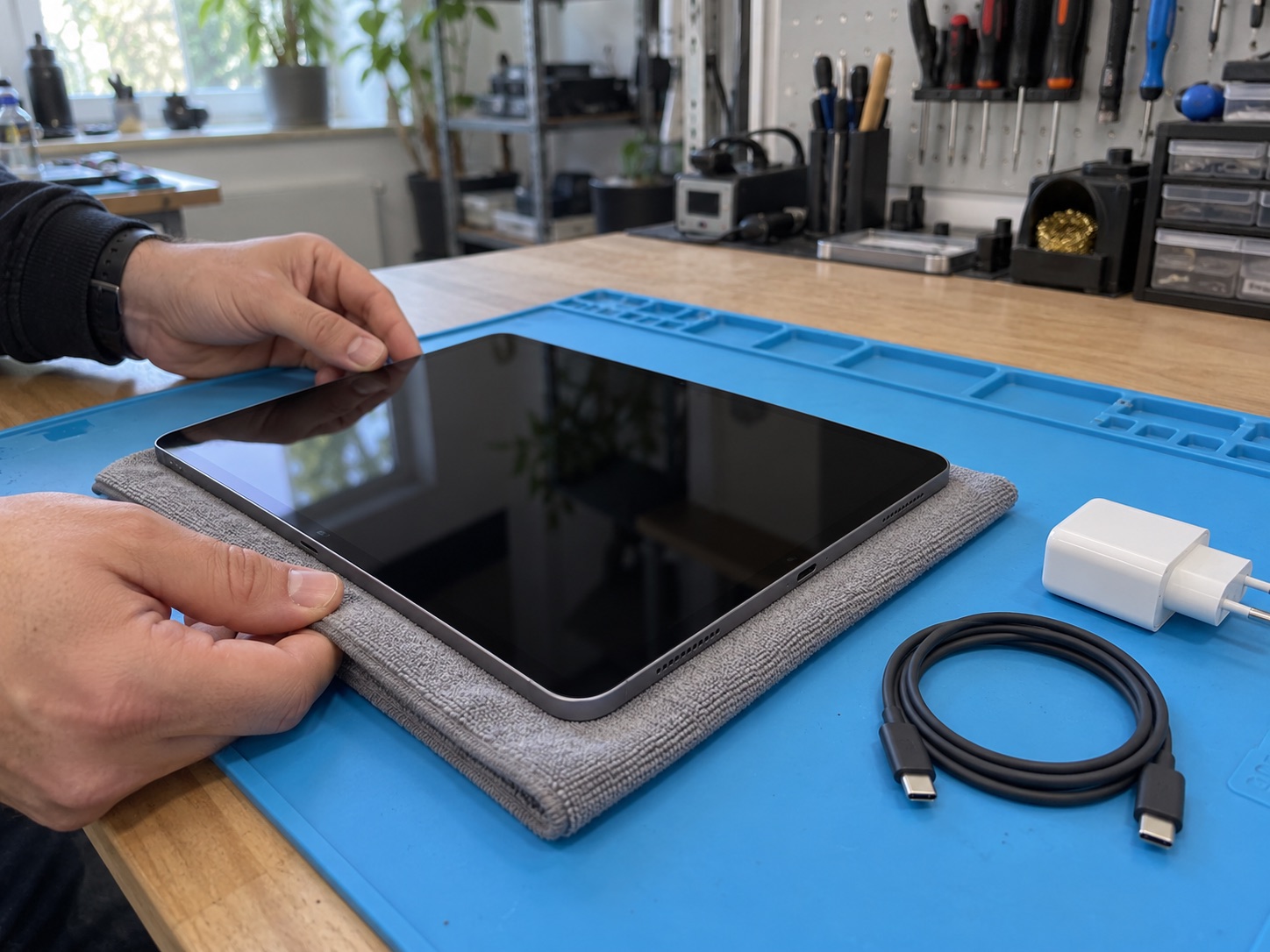 Kuru bez üzerinde ve şarjdan ayrılmış iPad Pro biçimindeki cihazın temsili atölye görünümü