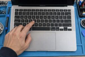 Atölyede MacBook Air biçimindeki cihazın klavye ve trackpad kontrolünü temsil eden sahne