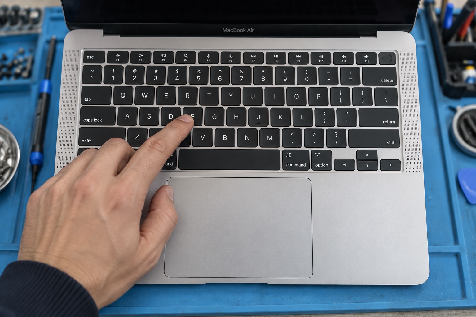 Atölyede MacBook Air biçimindeki cihazın klavye ve trackpad kontrolünü temsil eden sahne