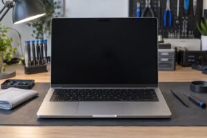 Atölyede siyah ekranlı MacBook Pro biçimindeki cihazın temsili ön görünümü