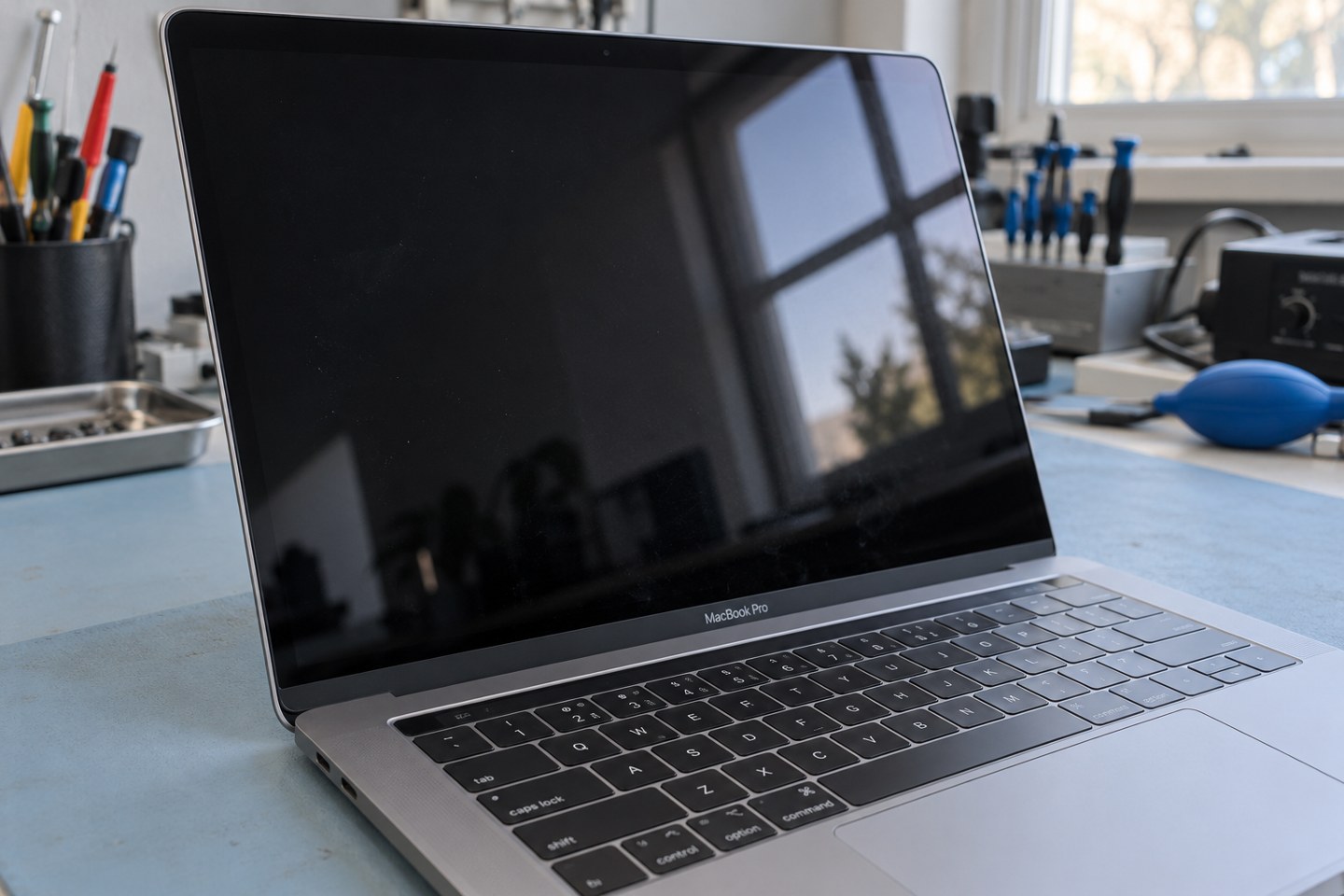 Yüzey lekesini incelemek için eğik ışık altında MacBook ekranı